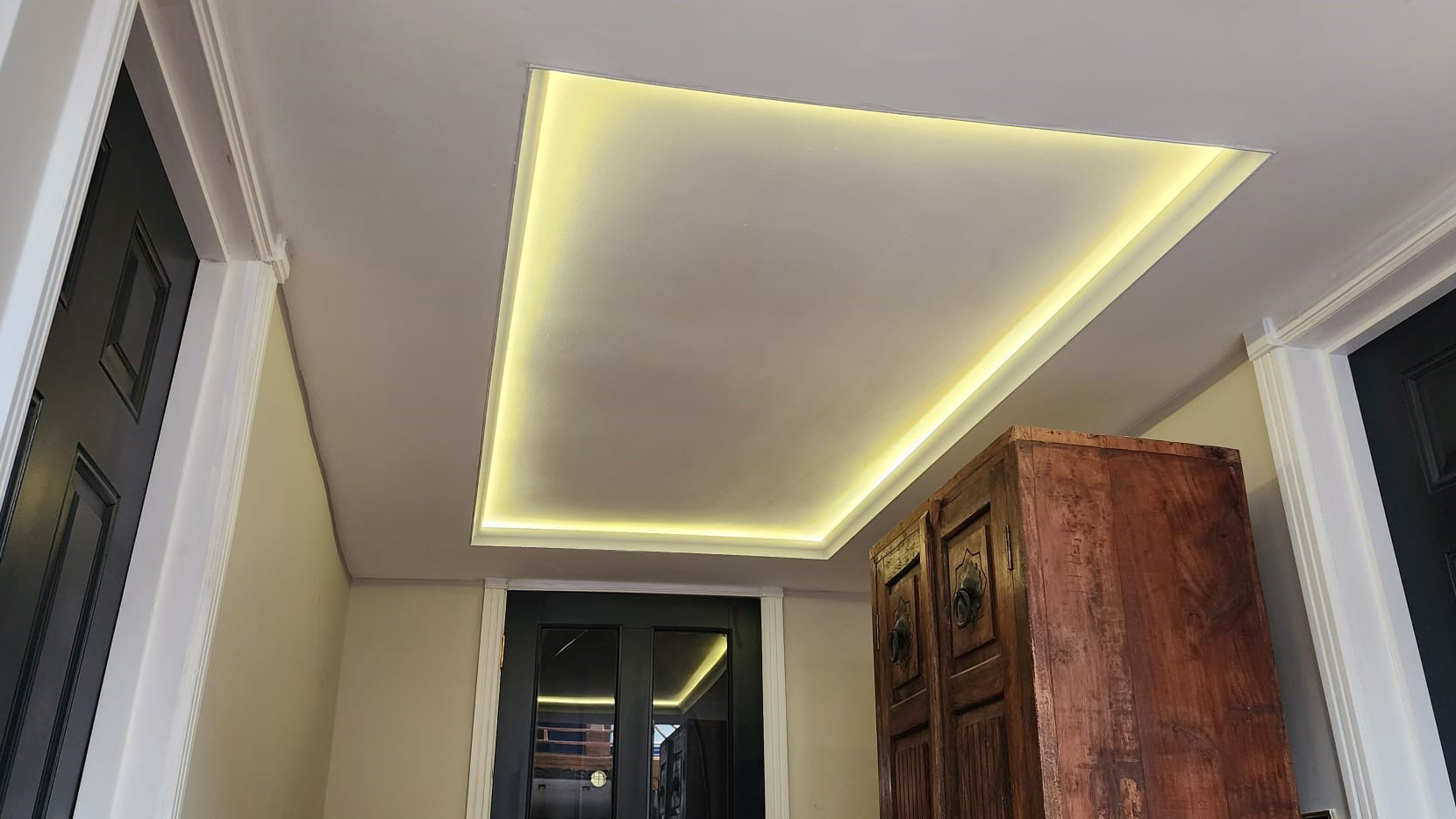 Bespoke ceiling with led lights attached within the cut out in the ceiling.